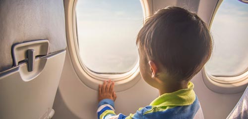 کودک در حال تماشا از پنجره هواپیما